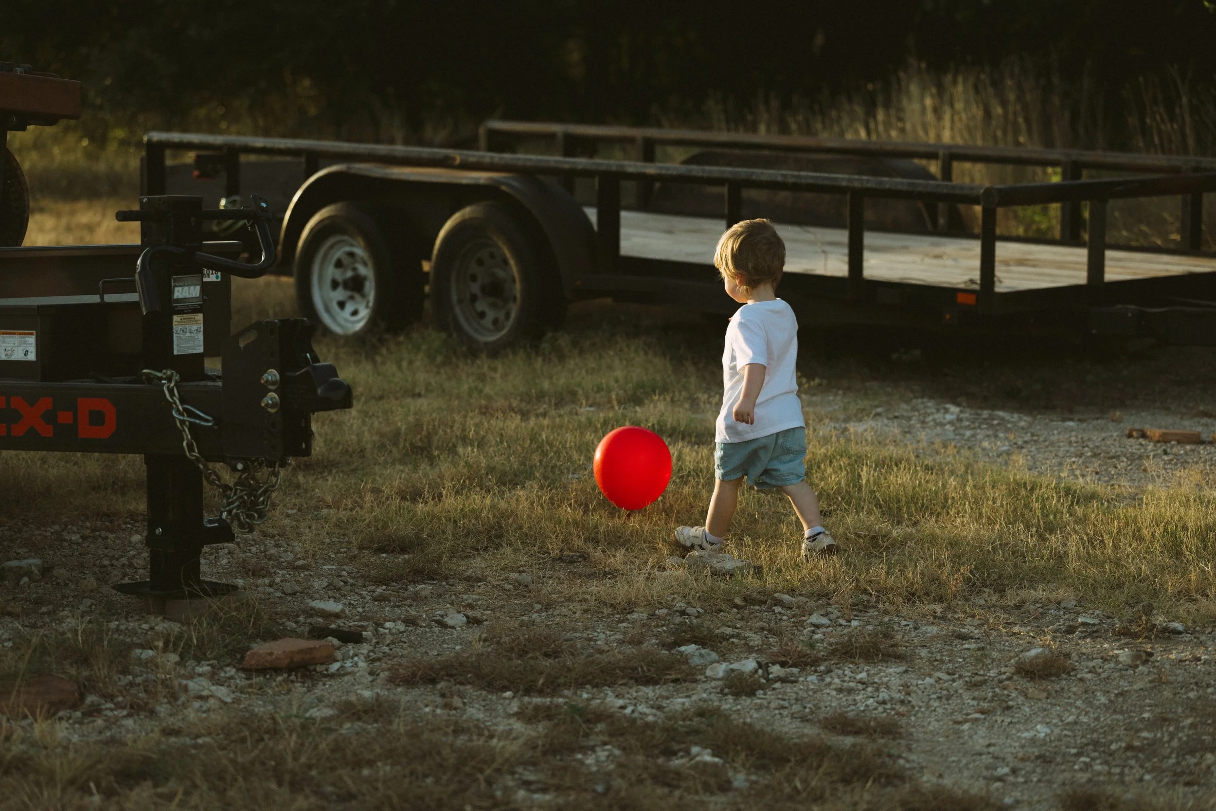 A little boy and a single red balloon in Salado Texas during a family session
